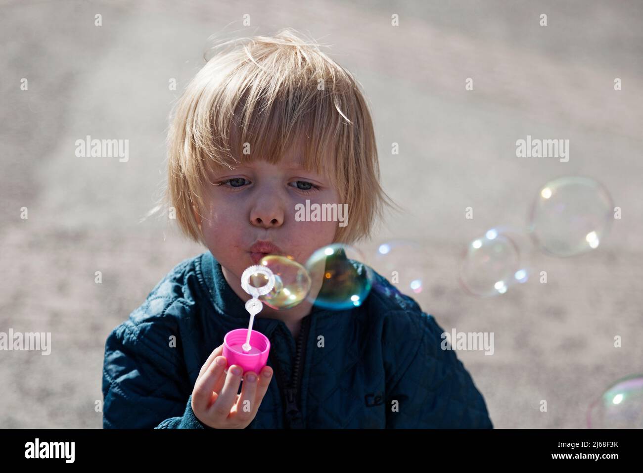 Umea, Norrland Schweden - 17. April 2022: Ein kleiner Junge bläst Seifenblasen Stockfoto