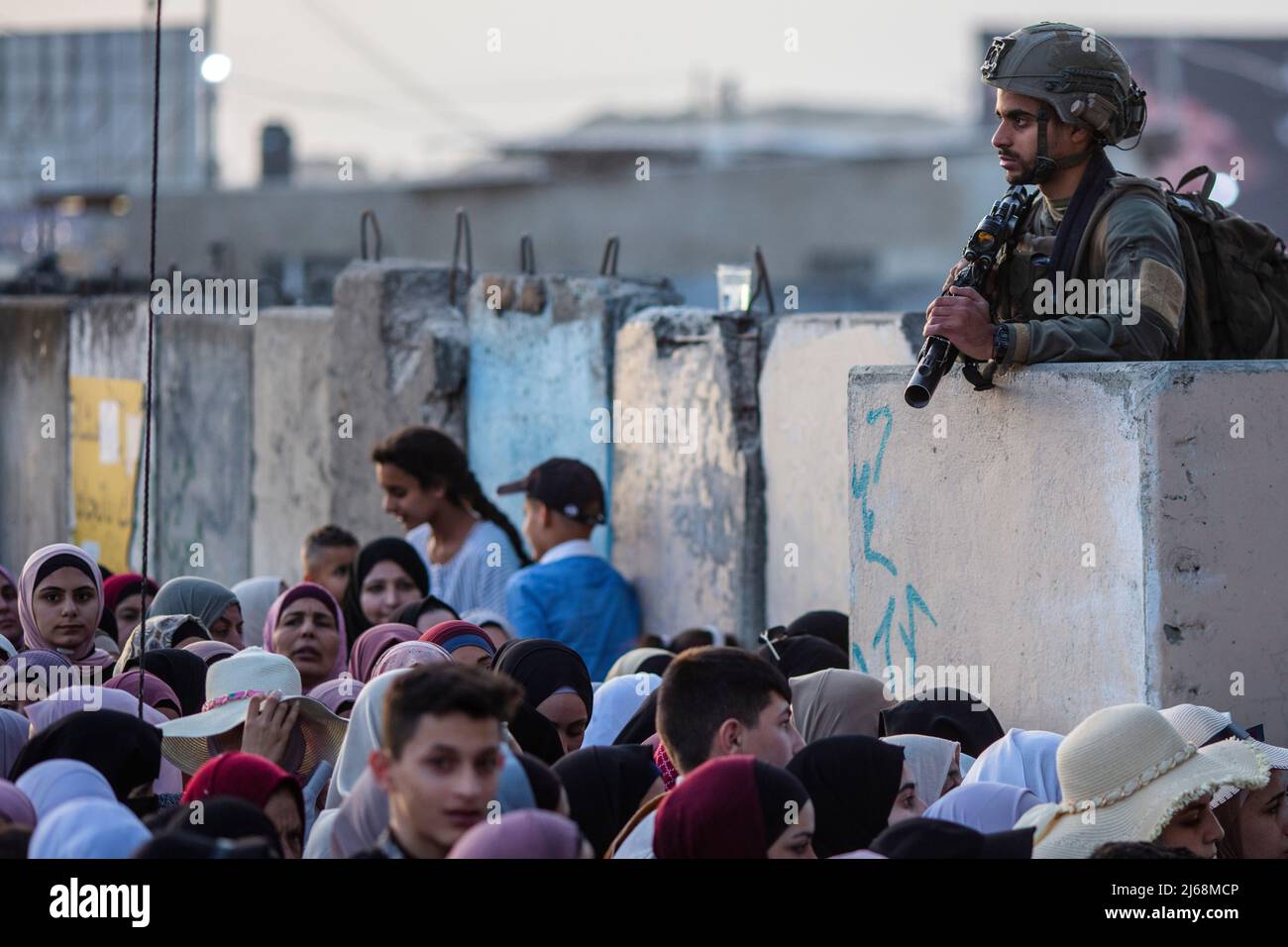 Ramallah, Palästina. 29. April 2022. 29. April 2022, Palästinensische Gebiete, Ramallah: Eine israelische Grenzpolizei steht Wache, als Palästinenser ihren Weg durch den Qalandia-Checkpoint gehen, um am letzten Freitaggebet des Fastenmonats Ramadan in der Al-Aqsa-Moschee teilzunehmen. Foto: Ilia Yefimovich/dpa Quelle: dpa picture Alliance/Alamy Live News Stockfoto