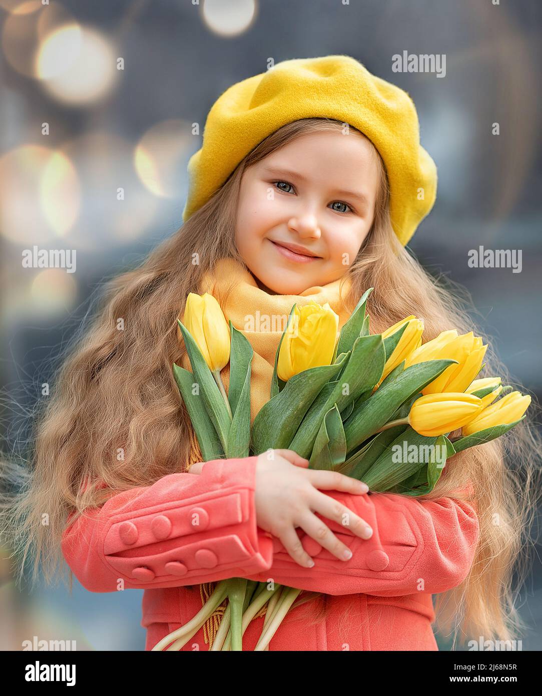 Porträt eines glücklichen Mädchens mit einem Strauß gelber Tulpen auf einem Spaziergang im Frühjahr. Blumen zum Internationalen Frauentag. Stockfoto