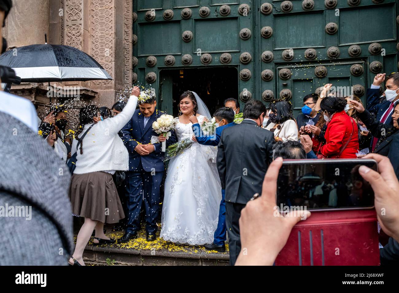 Ein junges peruanisches Paar verlasst die Kathedrale nach der Hochzeit, Cusco, Provinz Cusco, Peru. Stockfoto
