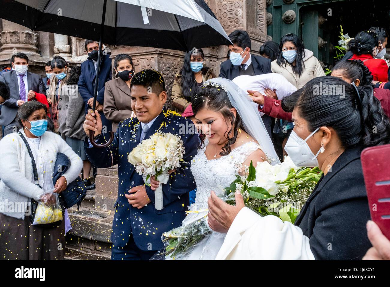 Ein junges peruanisches Paar verlasst die Kathedrale nach der Hochzeit, Cusco, Provinz Cusco, Peru. Stockfoto