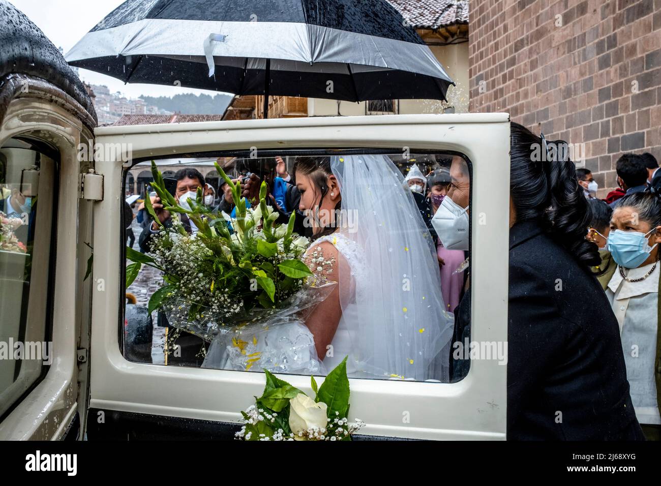 Ein junges peruanisches Paar kommt in ihr Hochzeitsauto, nachdem es in der Kathedrale, Plaza De Armas., Cusco, Provinz Cusco, Peru geheiratet hat. Stockfoto