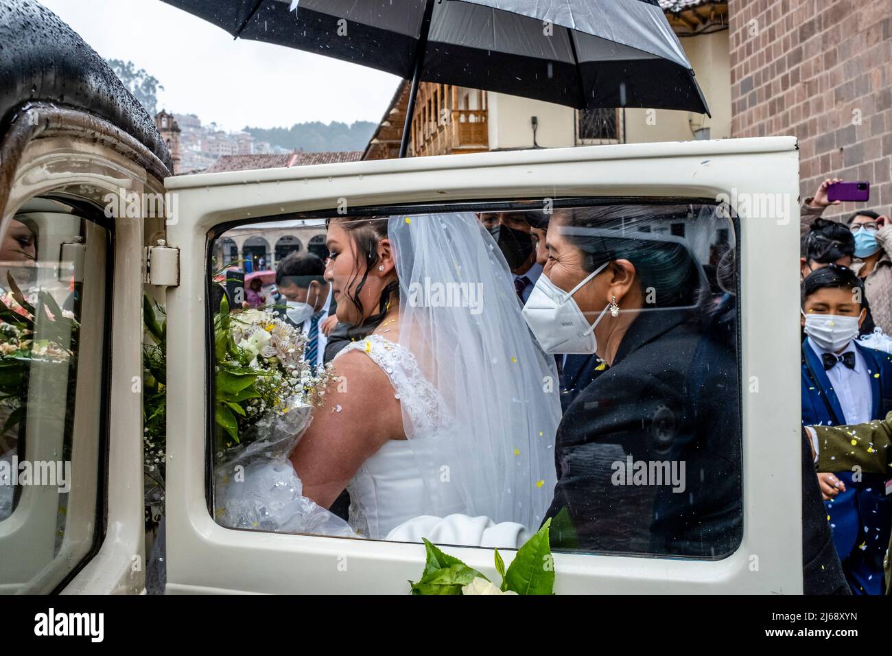 Ein junges peruanisches Paar kommt in ihr Hochzeitsauto, nachdem es in der Kathedrale, Plaza De Armas., Cusco, Provinz Cusco, Peru geheiratet hat. Stockfoto