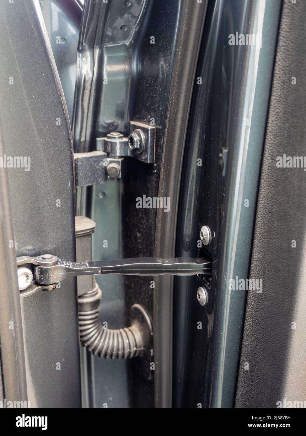 Nahaufnahme eines typischen Türscharniers im Auto und Details zu mechanischen und elektrischen Anschlüssen Stockfoto