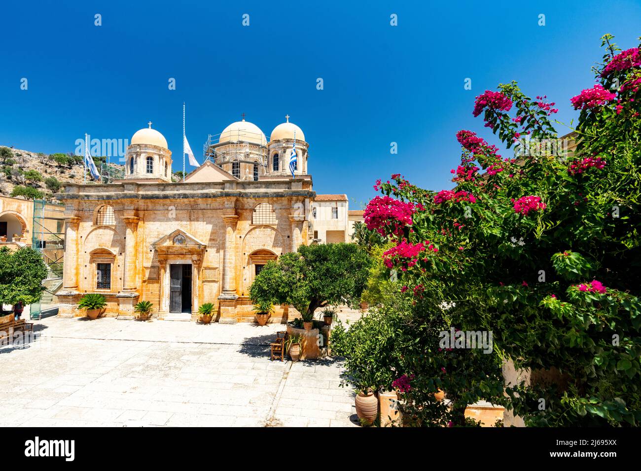 Fassade des alten Klosters Agia Triada von Tzagarolon, umgeben von Bougainvillea im Sommer, Kreta, griechische Inseln, Griechenland Stockfoto