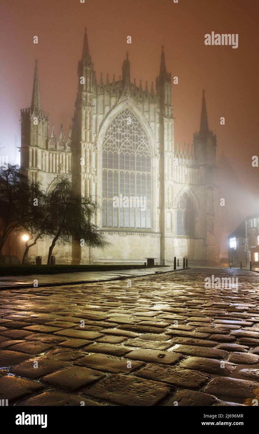 Eine stimmungsvolle, neblige Winteransicht von York Minsters Ostfenster nach Einbruch der Dunkelheit, York, Yorkshire, England, Großbritannien Stockfoto