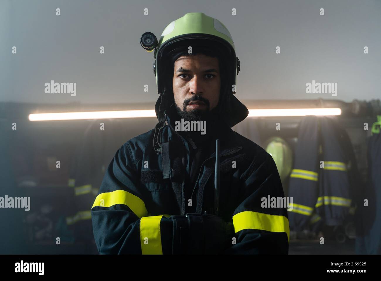 Junger afroamerikanischer Feuerwehrmann in der Feuerwache bei Nacht. Stockfoto