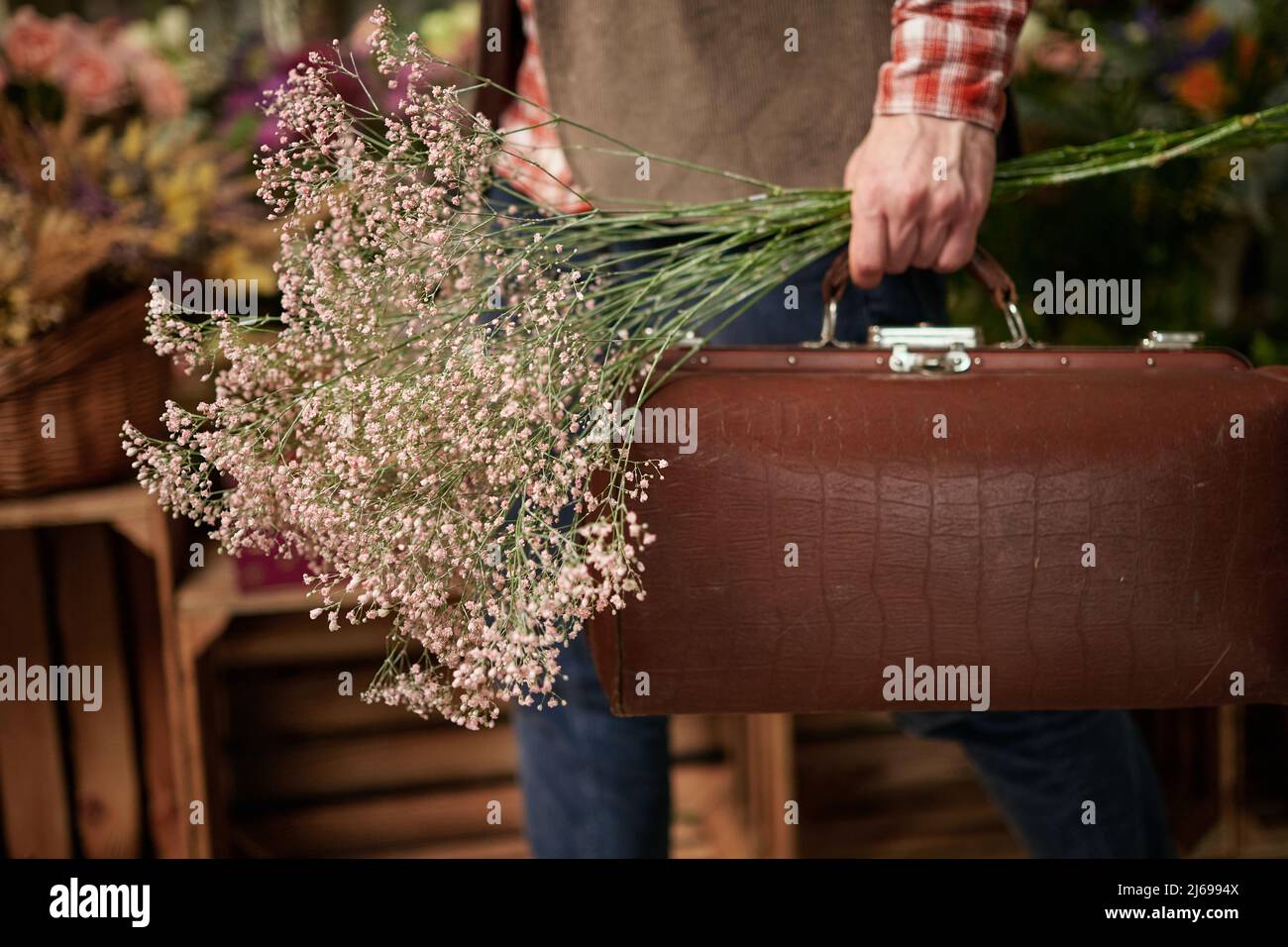 Konzept zum Muttertag, Valentinstag oder Internationalen Frauentag. Geschäftsmann im Hemd mit Ledertasche und schönem Blumenstrauß. Frische Frühlingsblumen. Hochwertige Fotos Stockfoto