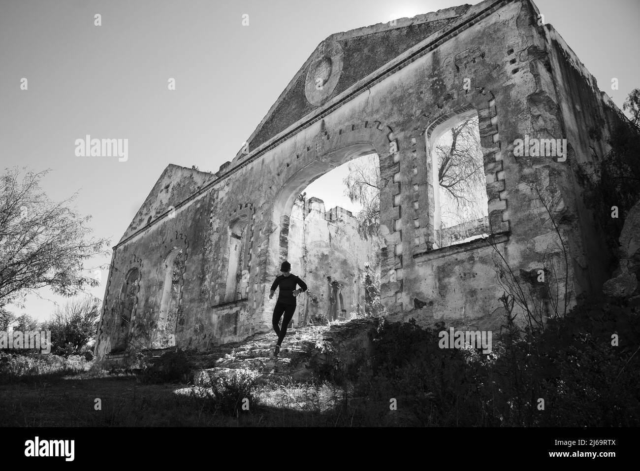 Die Frau rennt die Treppe eines Gebäudes bei einer verlassenen Hazienda hinunter Stockfoto