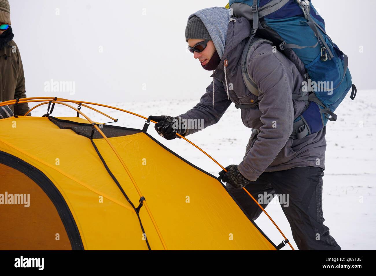 Zwei Jungs stellen im Schnee ein Zelt auf. Aufbau eines Zeltes während einer Winterexpedition unter extremen Bedingungen. Winterwanderungen Stockfoto