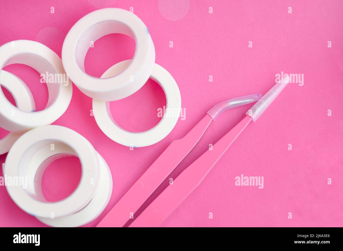 Pinzette für Wimpern-Erweiterungen auf rosa Hintergrund für Lashmakers Stockfoto