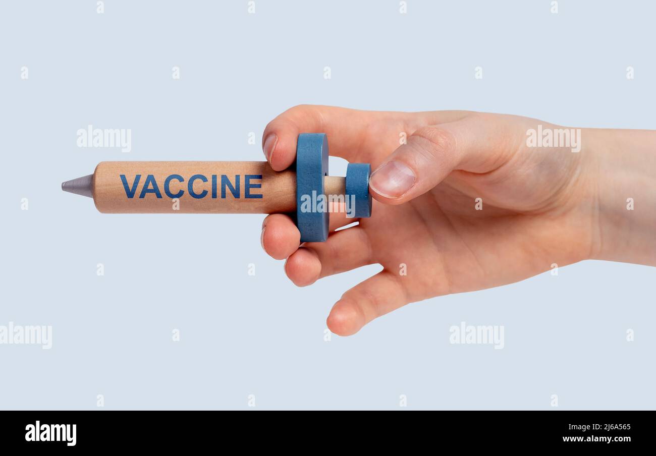 Impfkonzept. Spritzenmodell mit Wortimpfstoff in der Hand der Frau. COVID, Grippe, Masern, andere Krankheiten Immunisierung. Hochwertige Fotos Stockfoto