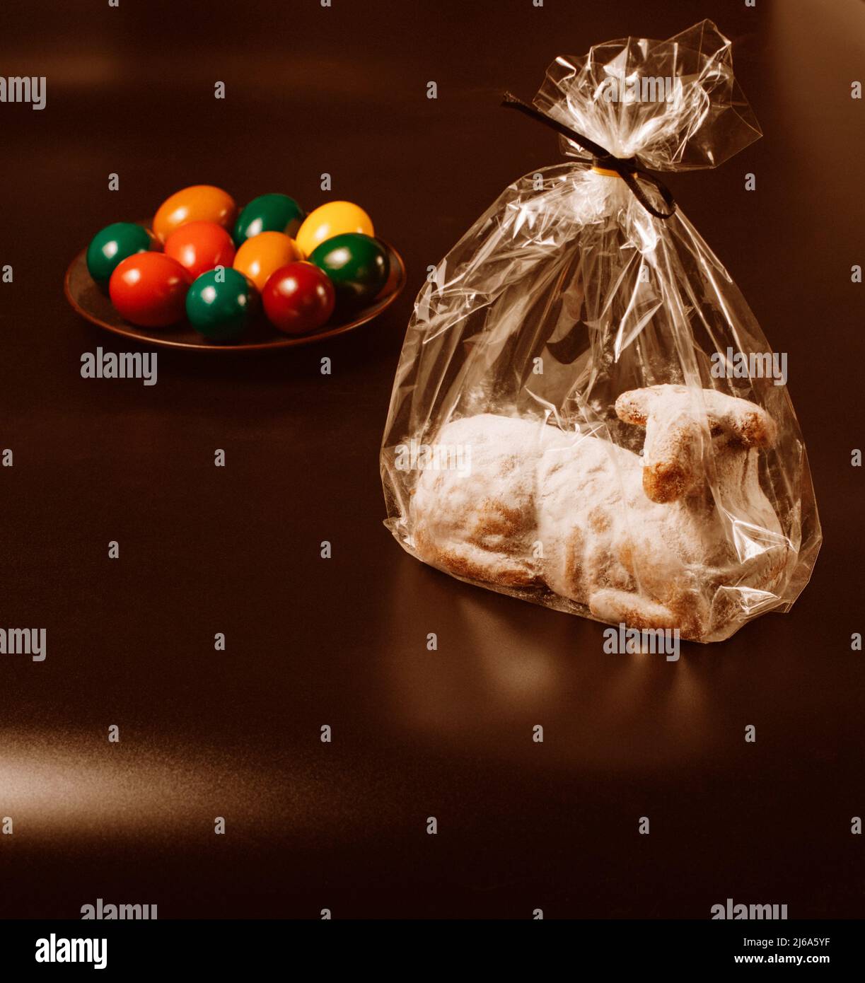 Osterlammkuchen in transparenter Verpackung und Eier auf braunem Hintergrund, Stockfoto Stockfoto Osterlammkuchen in transparenter Verpackung und Eier auf braunem Hintergrund, Stockfoto Stockfoto