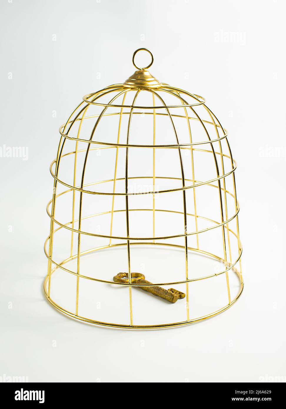 Großer goldener Vogelkäfig und Vintage-Schlüssel auf weißem Hintergrund, Konzept, Stock Foto Stockfoto