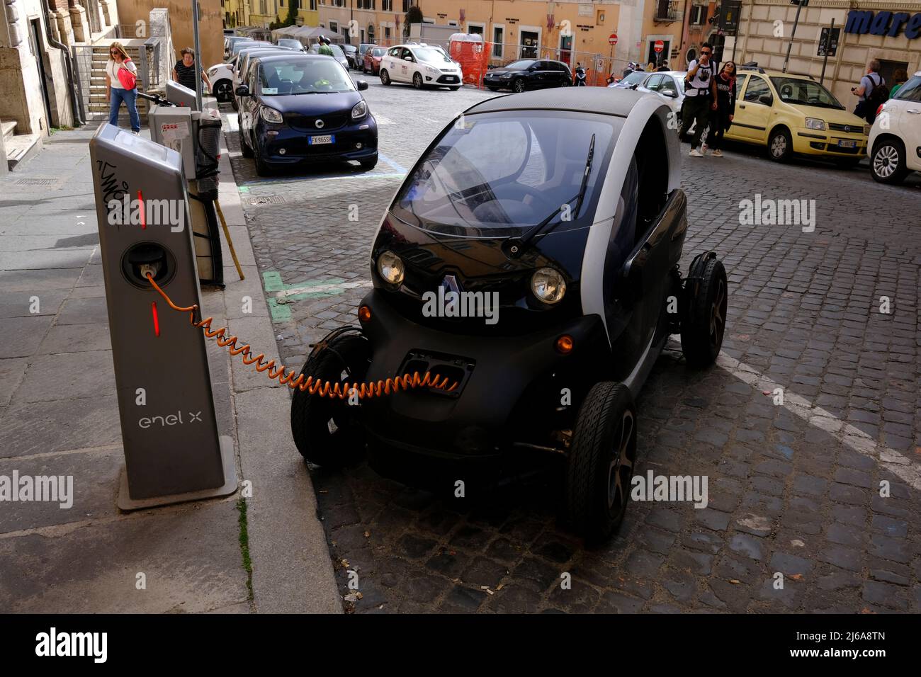 In Rom, Italien, lädt ein winziges Elektroauto auf der Straße Stockfoto