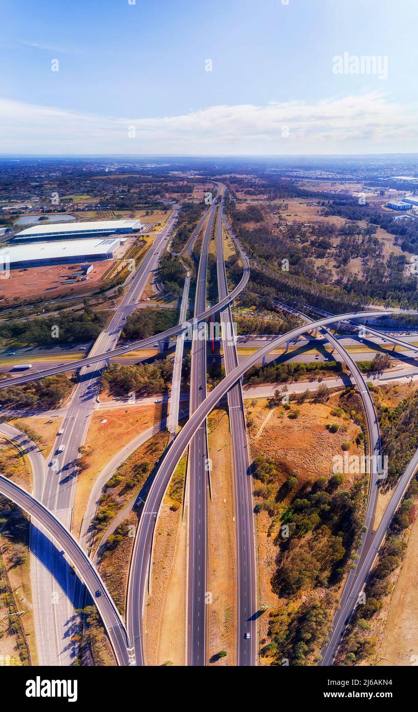 Mehrschichtige Autobahnkreuzung auf den highways M4 und M7 in Sydney West - vertikales Luftpanorama. Stockfoto