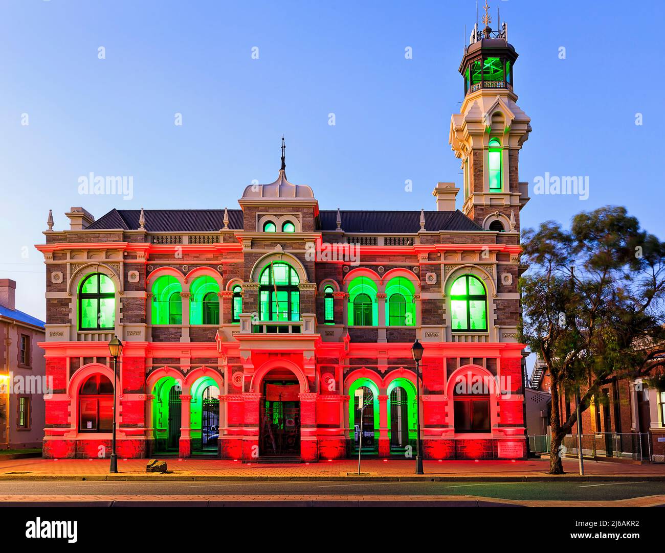 Bei Sonnenuntergang leuchtet die grüne rote Beleuchtung auf dem historischen Rathaus in Broken Hill im australischen Outback auf. Stockfoto