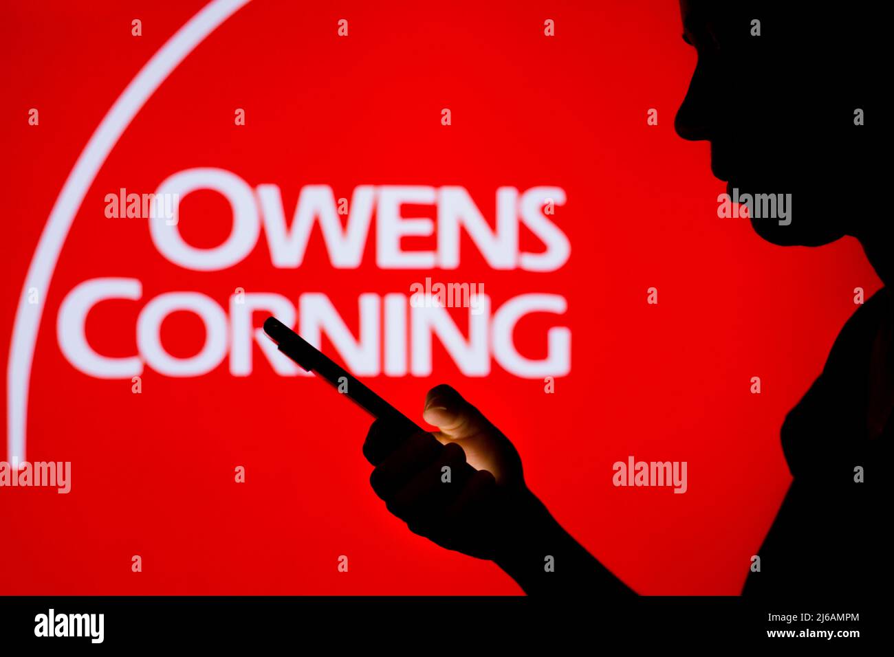 In dieser Fototafel ist das Owens Corning-Logo im Hintergrund einer Frau mit Silhouetten zu sehen, die ein Mobiltelefon in der Hand hält. (Foto von Rafael Henrique / SOPA Images/Sipa USA) Stockfoto