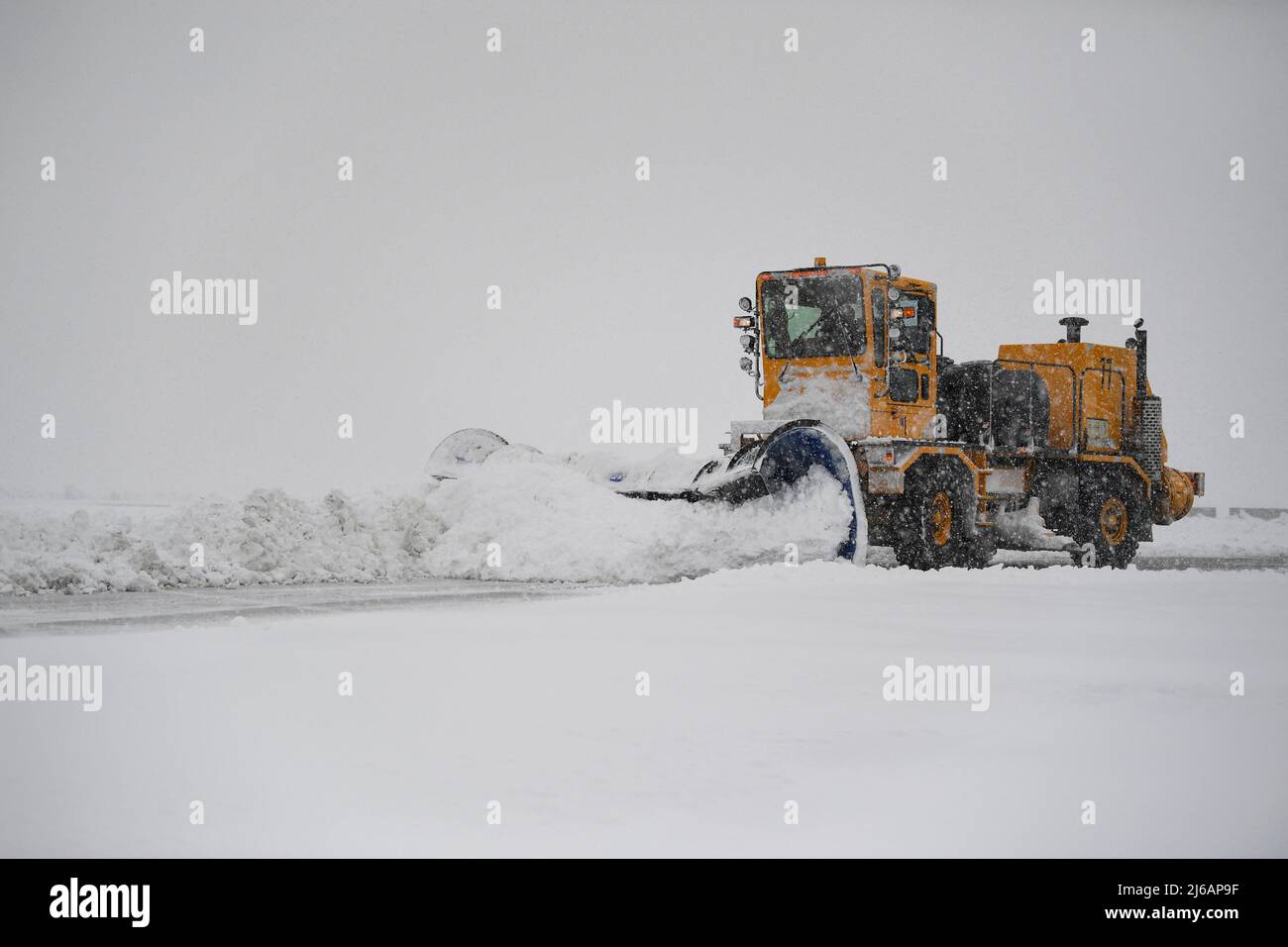 Ein Mitglied der 319. Civil Engineer Squadron nutzt einen Schneepflug, um die Fluglinie während eines Schneesturms auf der Grand Forks Air Force Base, N.D., 12. April 2022 zu räumen. Bei schlechtem Wetter arbeitet das Team Tag und Nacht daran, den Schnee zu räumen und den Flugplatz wieder in Betrieb zu nehmen. (USA Luftwaffe Foto von Senior Airman Dakota C. Legrand) Stockfoto