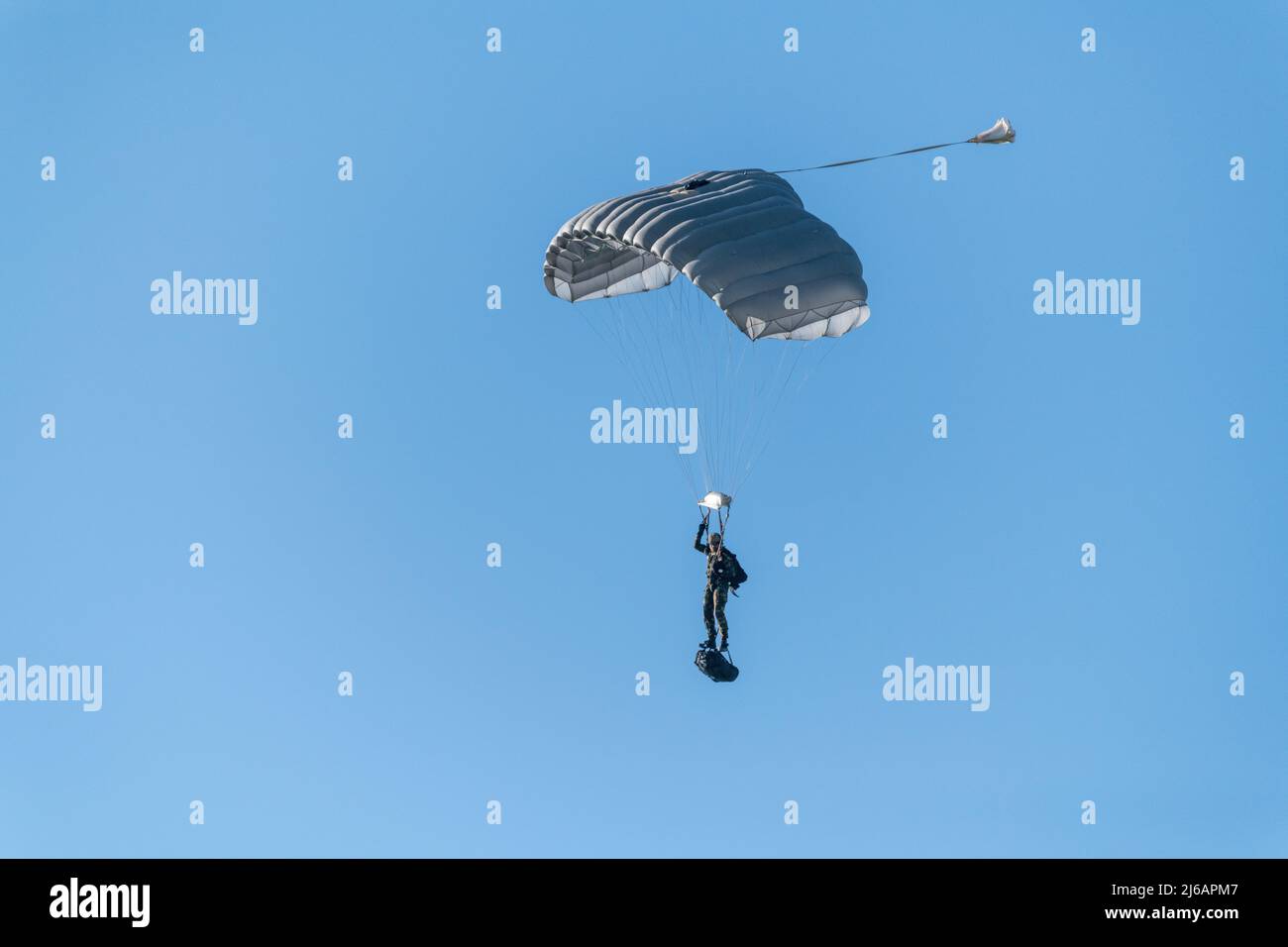 Ein belgischer Fallschirmjäger führt einen Freifallsprung mit einer Ladung unter Aufsicht von Jumpmastern durch, die dem CE para Trainingszentrum auf dem Luftwaffenstützpunkt Chièvres, Belgien, zugewiesen wurden, 20. April 2022. (USA Foto der Armee von Pierre-Etienne Courtejoie) Stockfoto