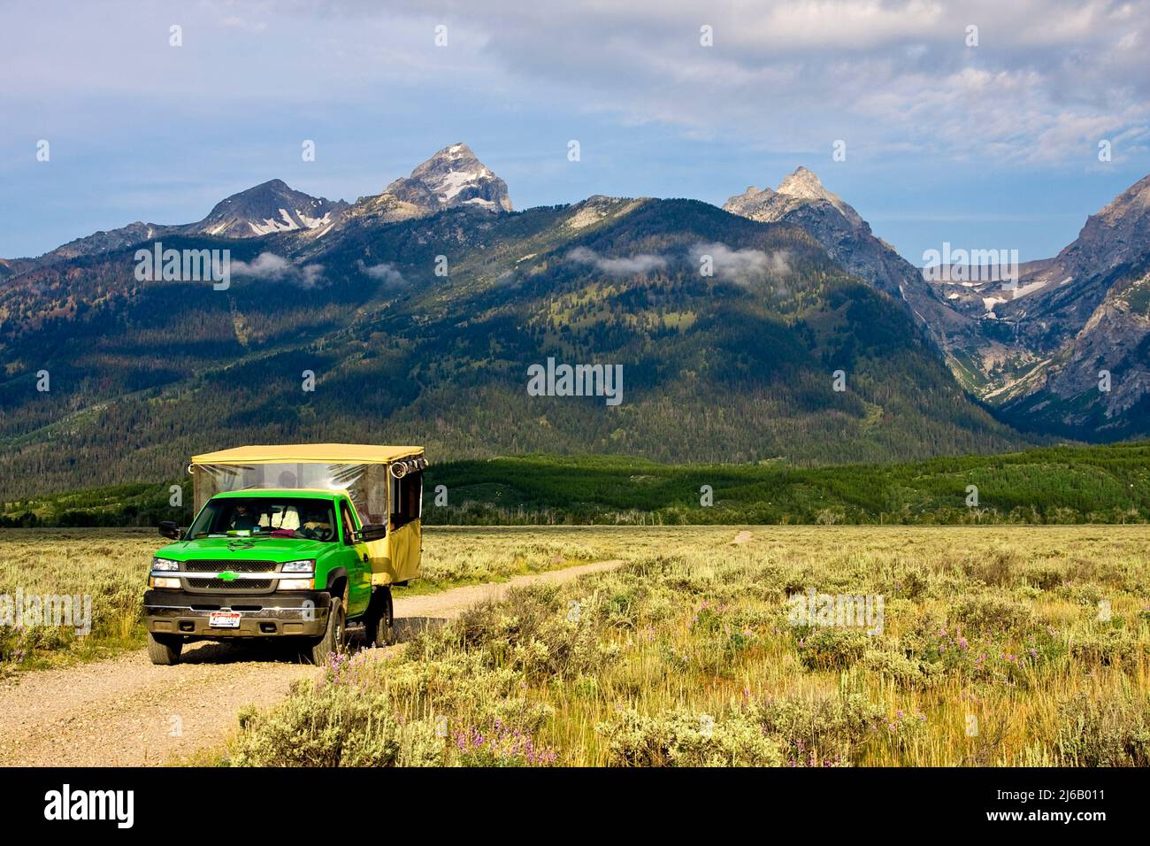 Tour Truck mit Touristen fahren abseits der Straße zur Bar BC Dude Ranch und Snake River. Stockfoto