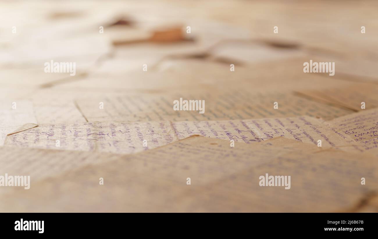 Tabelle mit vielen alten Buchstaben bedeckt. Winkelansicht, selektiver Fokus. Text ist nicht erkennbar Stockfoto