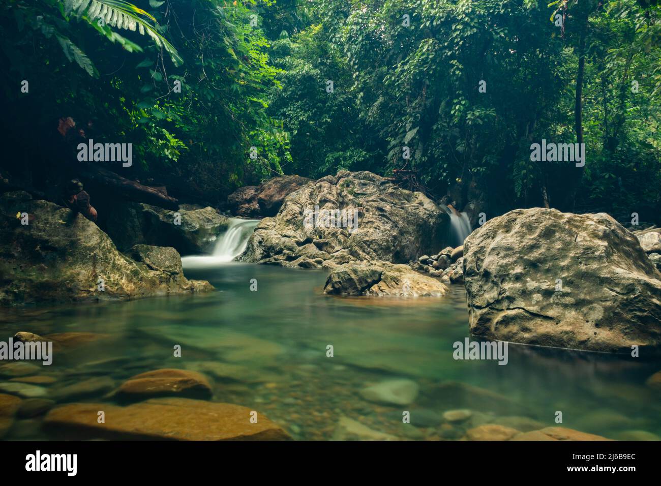 Wasser fließt über die Felsen. Blaues und klares Wasser in einem Bergfluss. Aceh, Indonesien Stockfoto