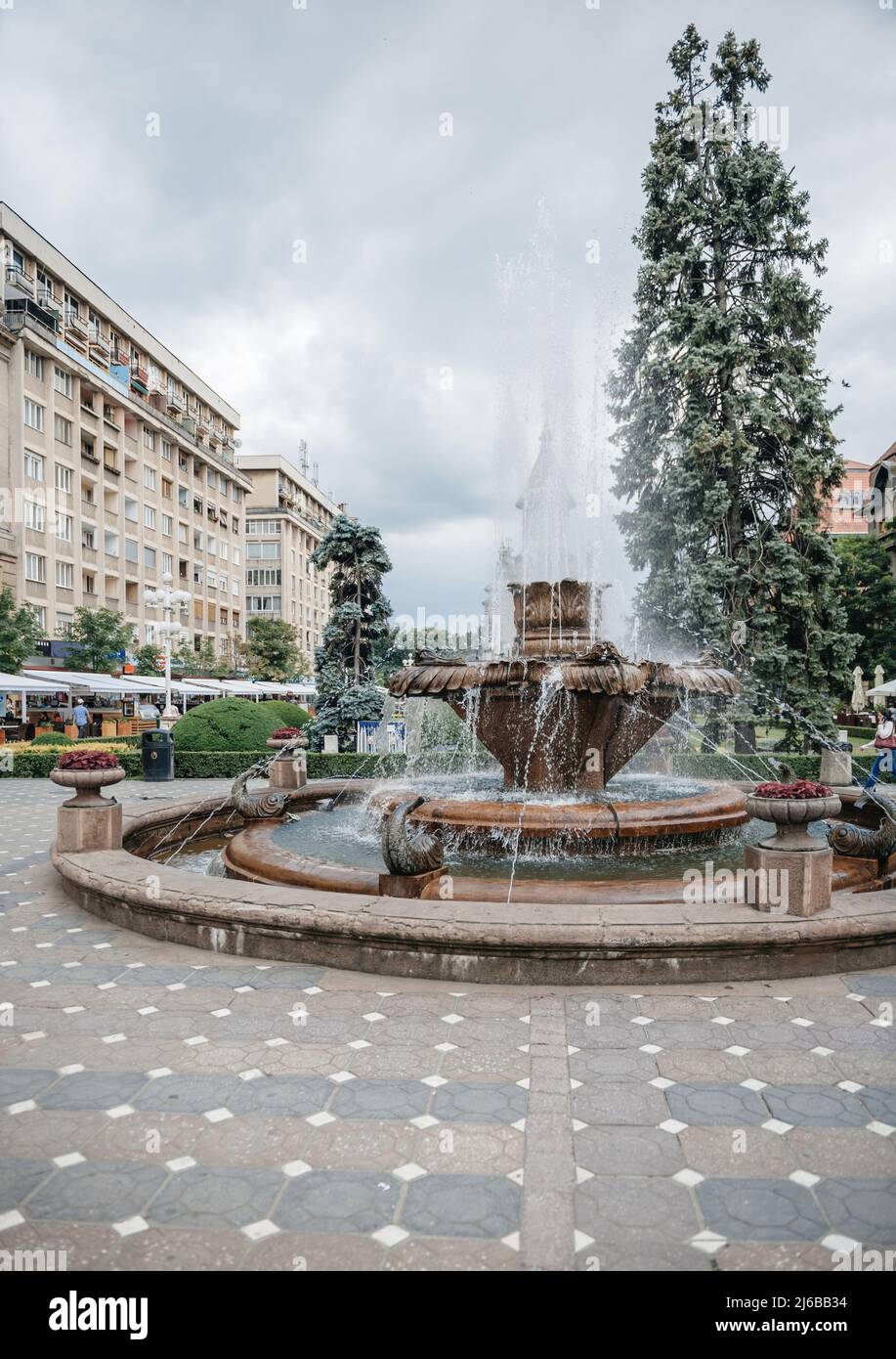 Timisoara, Rumänien - 18. Jun 2015: Ikonischer Fischbrunnen in Piata Victoriei mit hohen Wasserstrahlen an einem heißen Sommertag Stockfoto