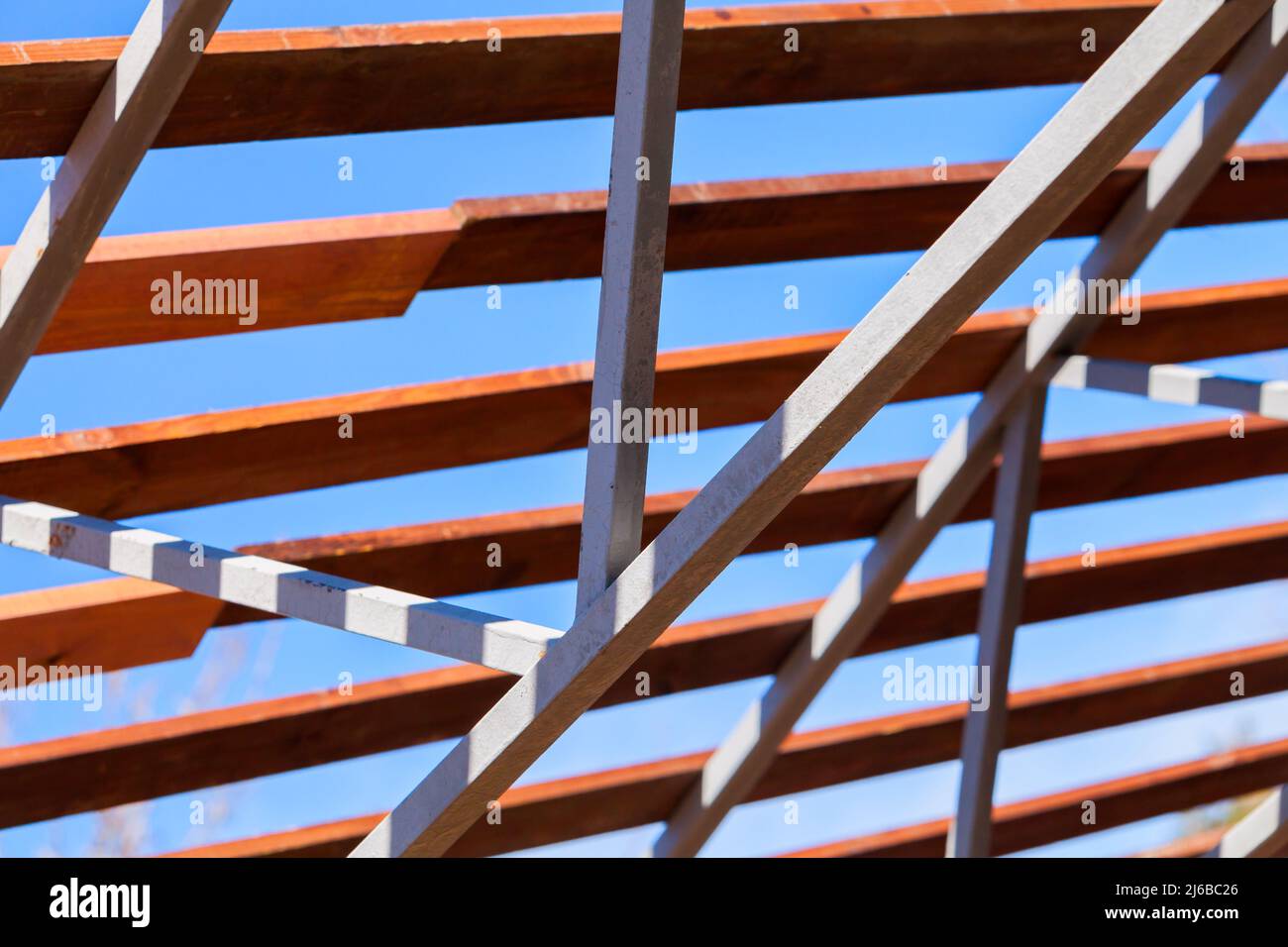 Stahldachrahmen mit Holzbrettern, moderne Konstruktion Struktur ist unter tiefblauem Himmel an einem sonnigen Sommertag Stockfoto