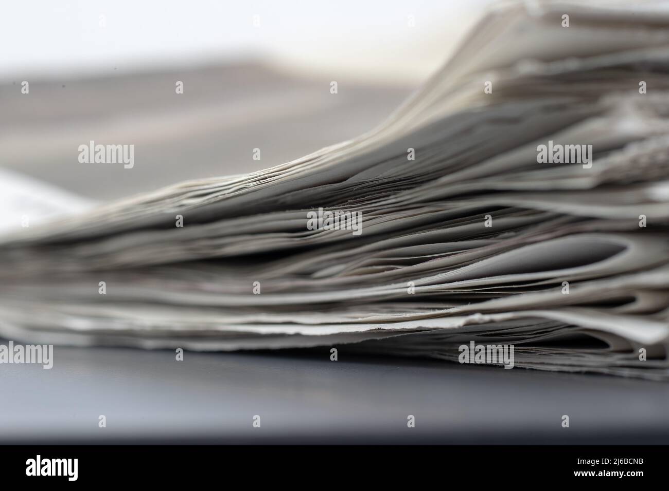 Makroaufnahme eines Stapels von Zeitungen. Die Zeitungen sind gefaltet und die Artikel sind nicht lesbar Stockfoto