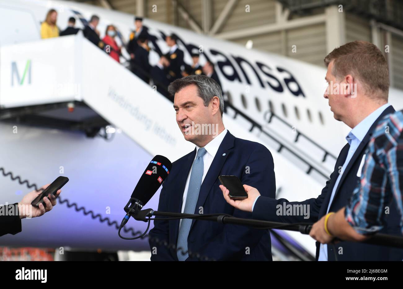 29. April 2022, Bayern, München: Ministerpräsident Markus Söder (CSU) gibt nach der Taufe eines Lufthansa Airbus A350 mit dem Namen „München“ in einem Wartungshangar am Flughafen München ein Interview. . Foto: Felix Hörhager/dpa Stockfoto