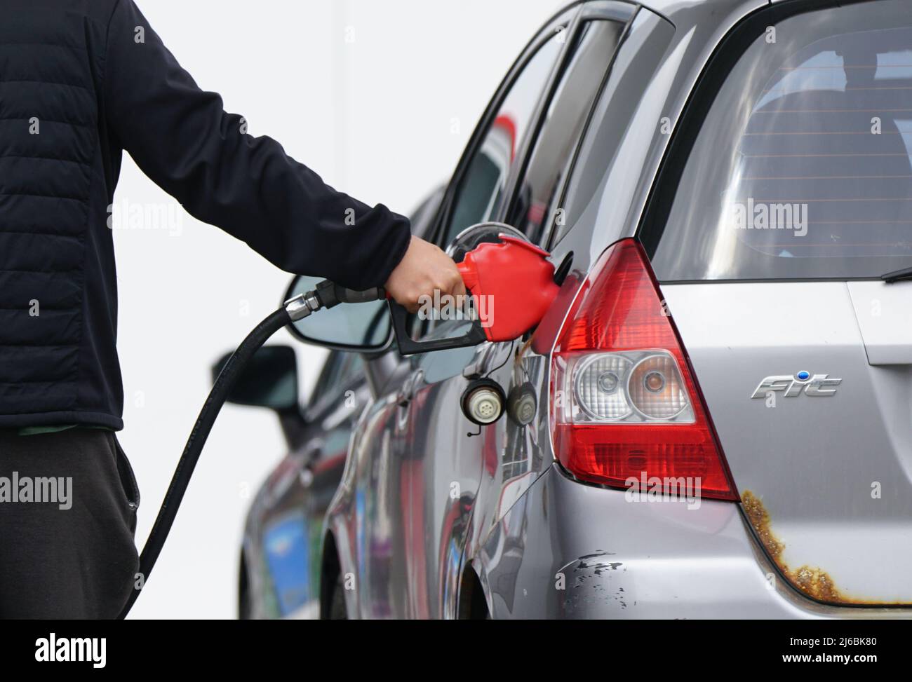 Mann an einer Tankstelle, die mit Benzin gefüllt ist. Stockfoto