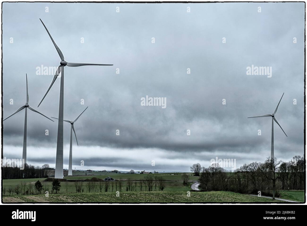Eolienne dans les campagnes Wallones sous un ciel nuageux Windkraftanlage unter bewölktem Himmel Elektrizitätsnetz mit Windkraftanlage Reseau elektrique Stockfoto