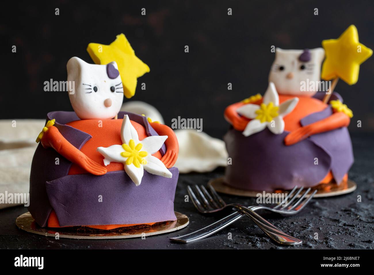 Gestalten Sie Kuchen mit Katzenfiguren auf dunklem Hintergrund. Nahaufnahme Stockfoto