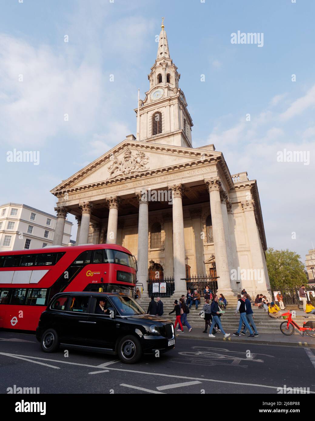 London, Greater London, England, 23 2022. April: Taxi und Bus warten im Verkehr vor der St. Martin in the Fields Church, während die Leute auf den Kirchenstufen sitzen Stockfoto