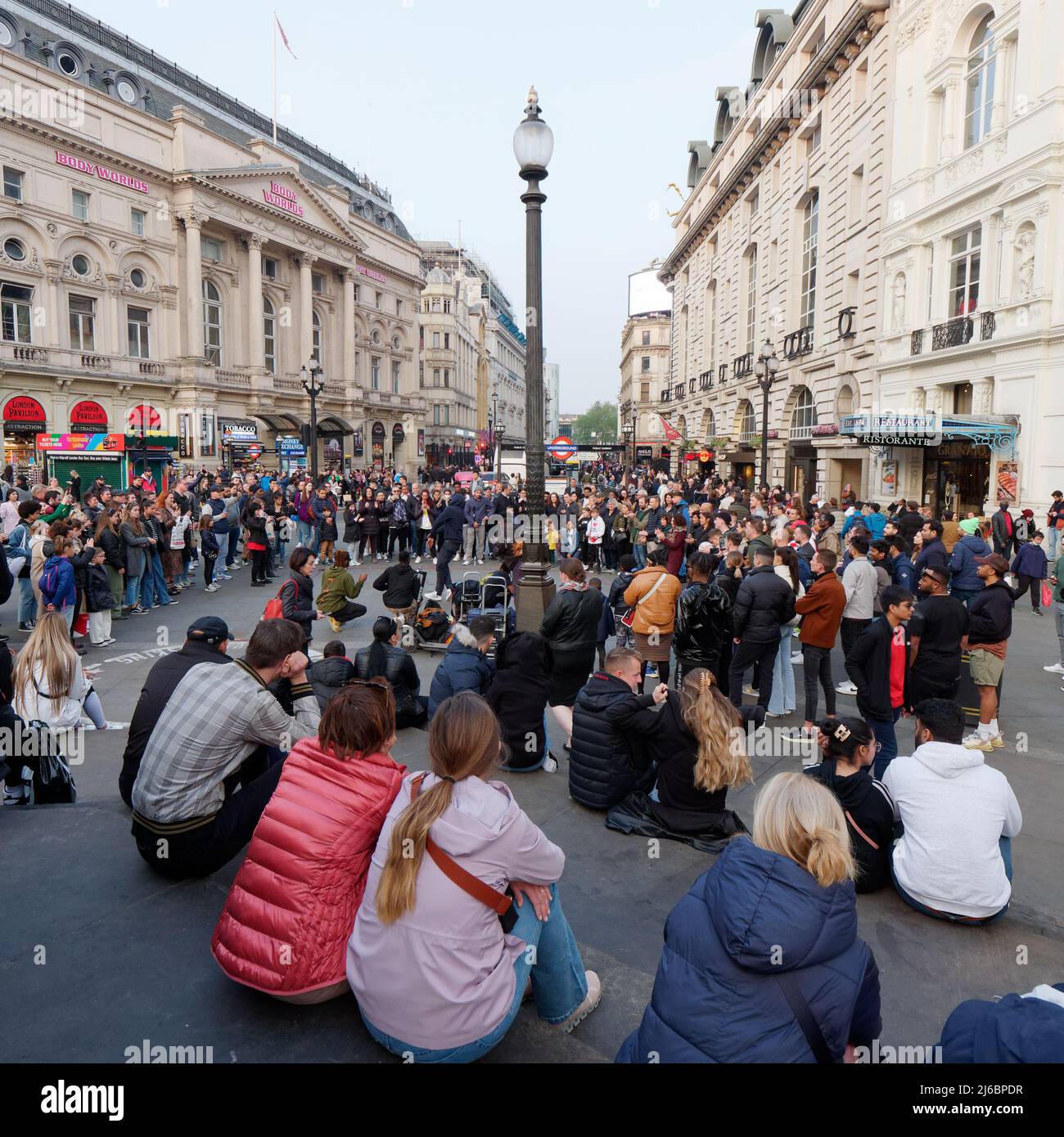 London, Greater London, England, April 23 2022: Menschenmassen versammeln sich im Piccadilly Circus, um sich die Straßenunterhaltung anzusehen. Stockfoto
