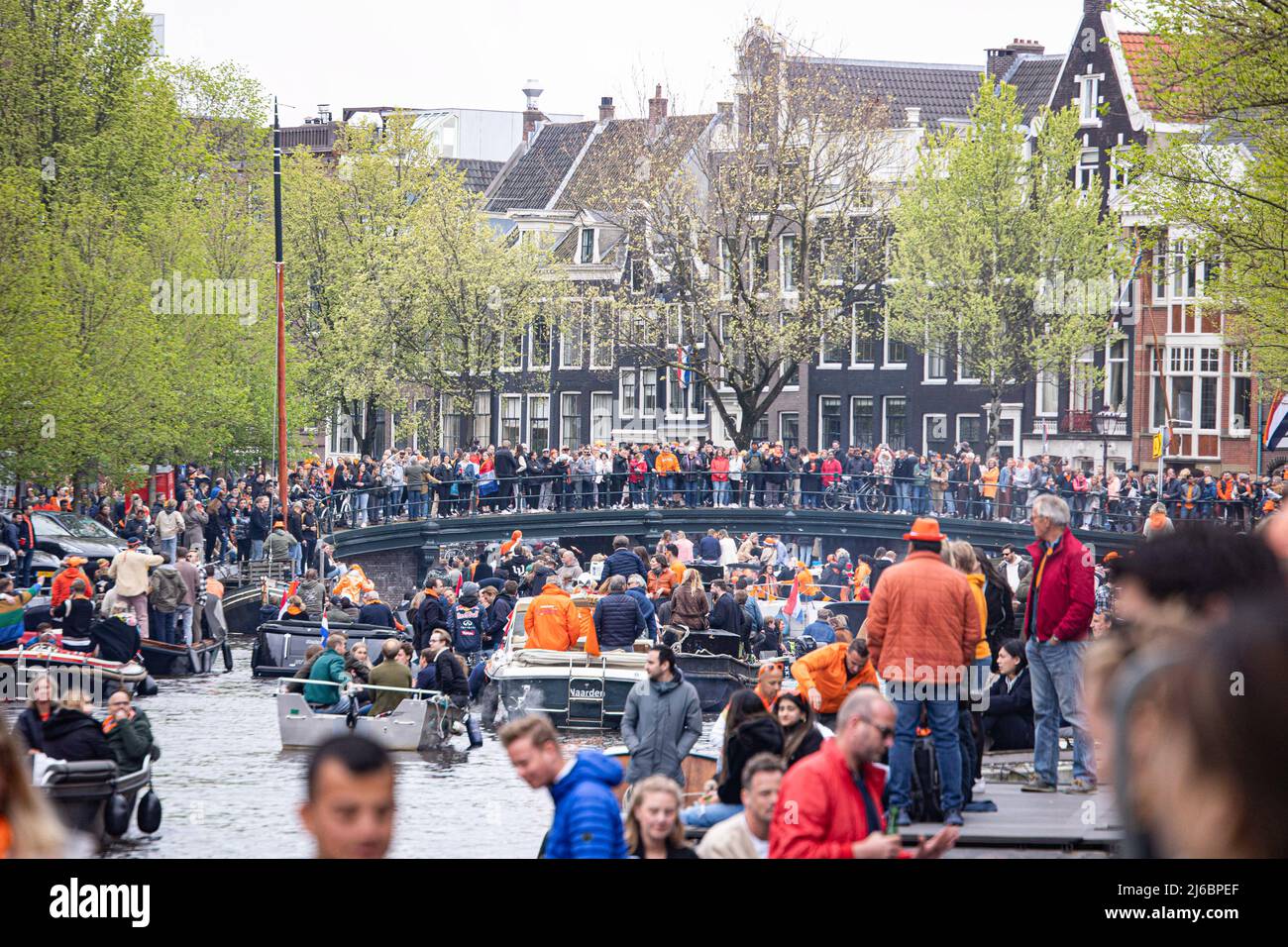 27. April 2022, Amsterdam, Niederlande: Menschen auf den Booten in den Grachten von Amsterdam während der Feier des Königs gesehen. Der Königstag, bekannt als Koningsdag, ist ein orangefarbenes Fest zum Geburtstag des Königs, ein Nationalfeiertag voller Veranstaltungen im ganzen Land. Tausende von Einheimischen und Touristen besuchten Amsterdam, um an den Kanälen zu feiern und zu feiern, während sie orangefarbene Kleidung trugen und die Boote eine Parade in den Wasserkanälen machten. (Bild: © Nik Oiko/SOPA Images via ZUMA Press Wire) Stockfoto