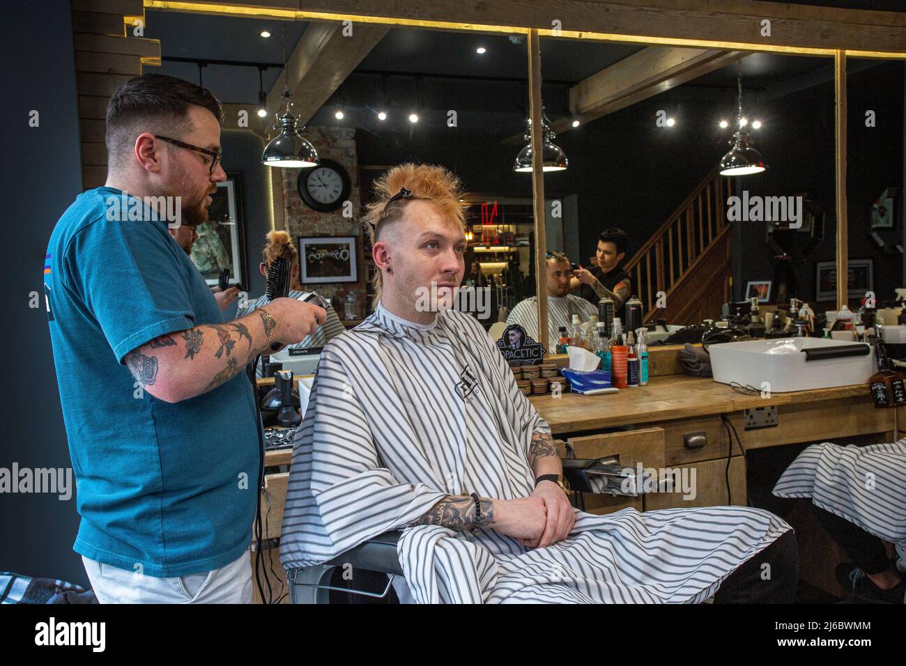 Friseur schneidet Haare in einem Friseurladen Wakefield, West Yorkshire, England. Stockfoto