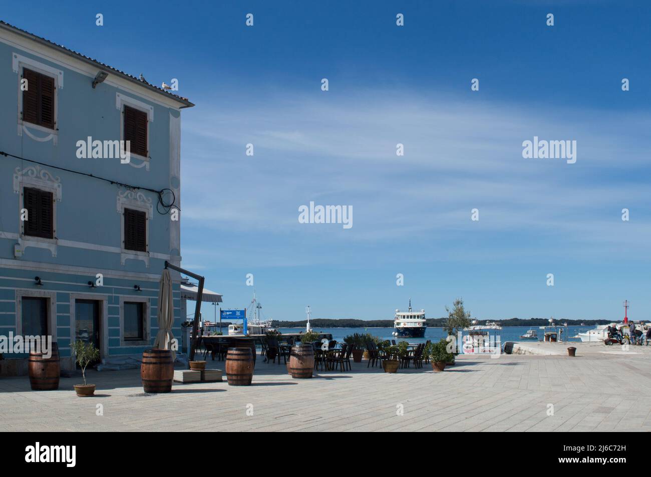 Fazana, Kroatien - 11. April 2022: Schöner Stadtplatz mit Terrassen, Abfahrtshafen für den Bootstransfer zum Nationalpark Brijuni Inseln Stockfoto