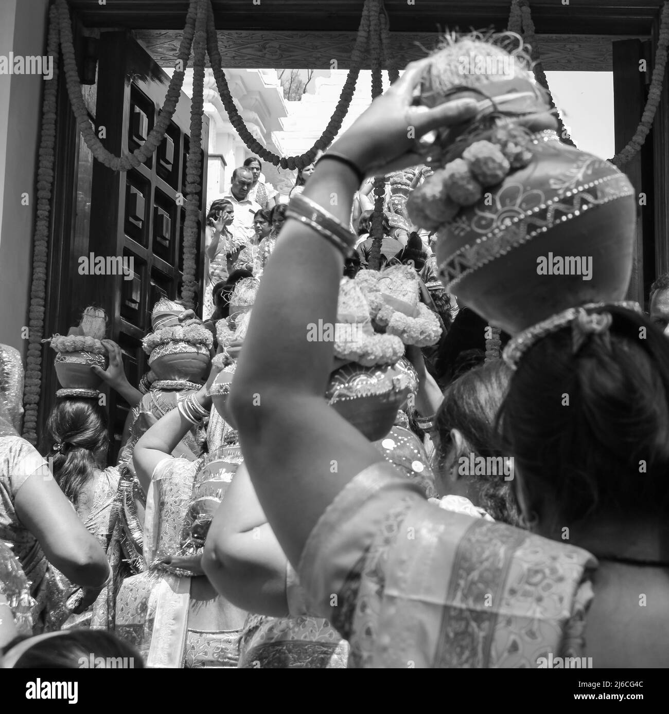 Frauen mit Kalash am Kopf während des Jagannath-Tempels Mangal Kalash Yatra tragen indische Hindu-Anhänger irdische Töpfe mit heiligem Wasser und Kokosnuss o Stockfoto