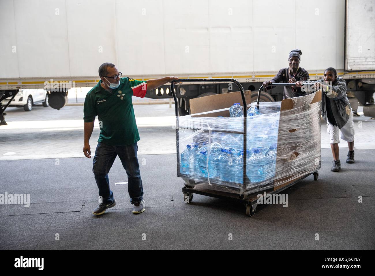 (220430) -- KAPSTADT, 30. April 2022 (Xinhua) -- ein Mitarbeiter der Schenkung der Schenkungsstiftung und Freiwillige fahren am 30. April 2022 in Kapstadt, Südafrika, einen Wagen mit gespendetem Mineralwasser. Viele Einwohner von Kapstadt reagierten auf einen Aufruf von Gift der Givers Foundation, einer Nichtregierungsorganisation zur Katastrophenhilfe, Flaschen Wasser für die Opfer von Überschwemmungen in der Provinz KwaZulu-Natal zu spenden. (Xinhua/Lyu Tianran) Stockfoto