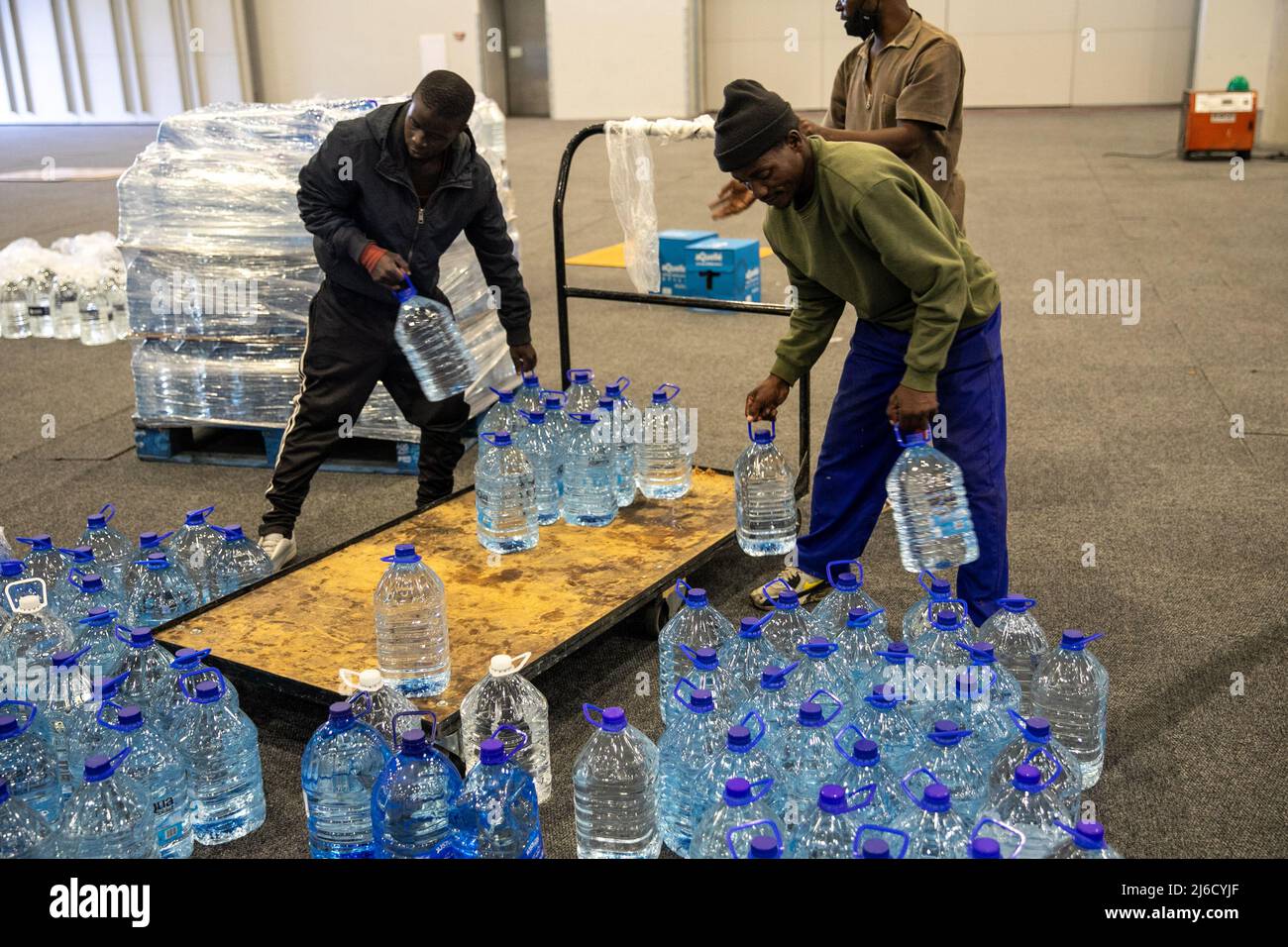 (220430) -- KAPSTADT, 30. April 2022 (Xinhua) -- Freiwillige tragen am 30. April 2022 gespendetes Mineralwasser in Kapstadt, Südafrika. Viele Einwohner von Kapstadt reagierten auf einen Aufruf von Gift der Givers Foundation, einer Nichtregierungsorganisation zur Katastrophenhilfe, Flaschen Wasser für die Opfer von Überschwemmungen in der Provinz KwaZulu-Natal zu spenden. (Xinhua/Lyu Tianran) Stockfoto