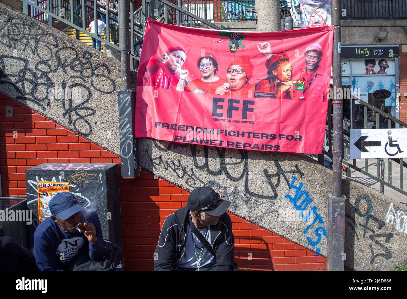 Während einer internationalistischen Friedensmesse in Brixton wird ein Banner der wirtschaftlichen Freiheitskämpfer gesehen, während die Menschen den Rednern zuhören. Die Economic Freedom Fighters (EFF) ist eine südafrikanische radikale und militante wirtschaftliche Emanzipationsbewegung unter der Führung von Julius Malema. Stockfoto