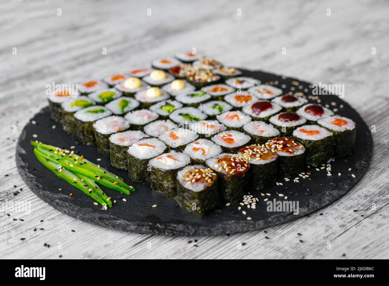 Sushi-Rolle mit Lachs, Thunfisch, Avocado und Gurke. Traditionelles japanisches Essen. Eine Menge Maki. Sushi-Brötchen. Draufsicht Stockfoto