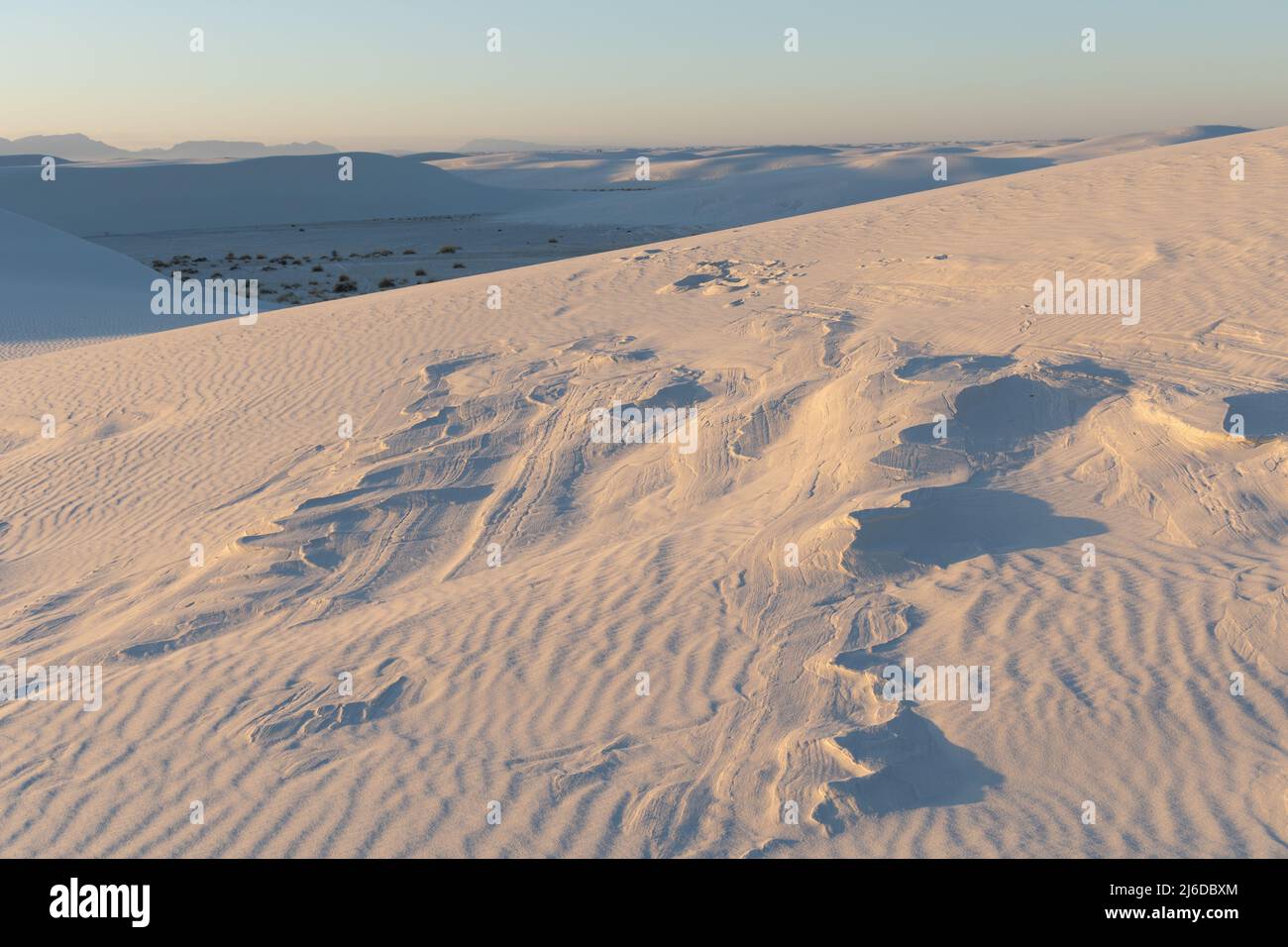 Bei Sonnenuntergang brechen im White Sands National Park Formationen aus gehärtetem Sand durch die Gipssanddünen Stockfoto