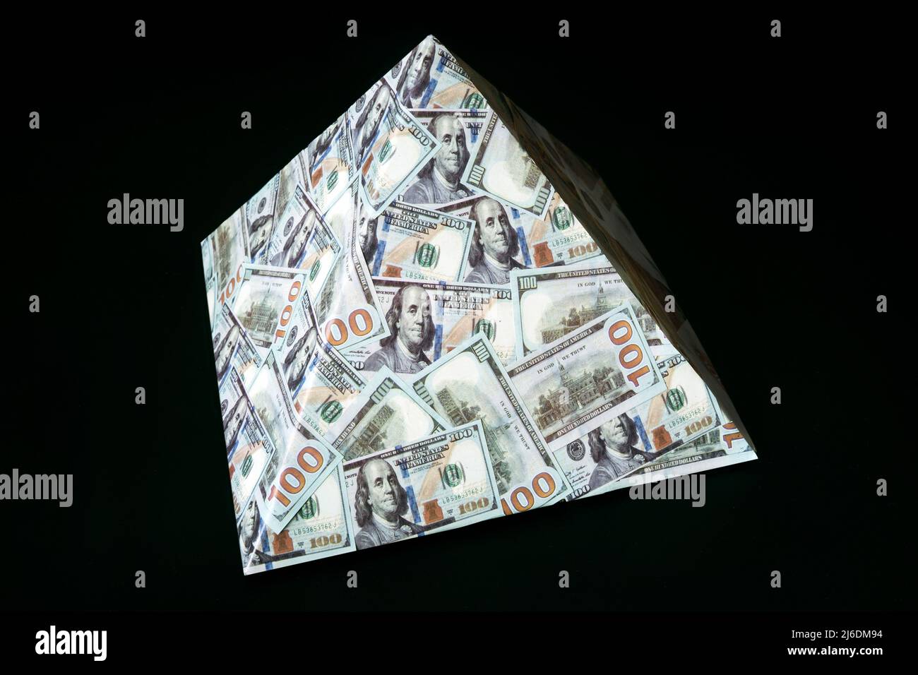 Ein Pyramidenschema auf schwarzem Hintergrund. Das Konzept des Finanzbetrugs. Der Dollar als globale Finanzpyramide. Stockfoto