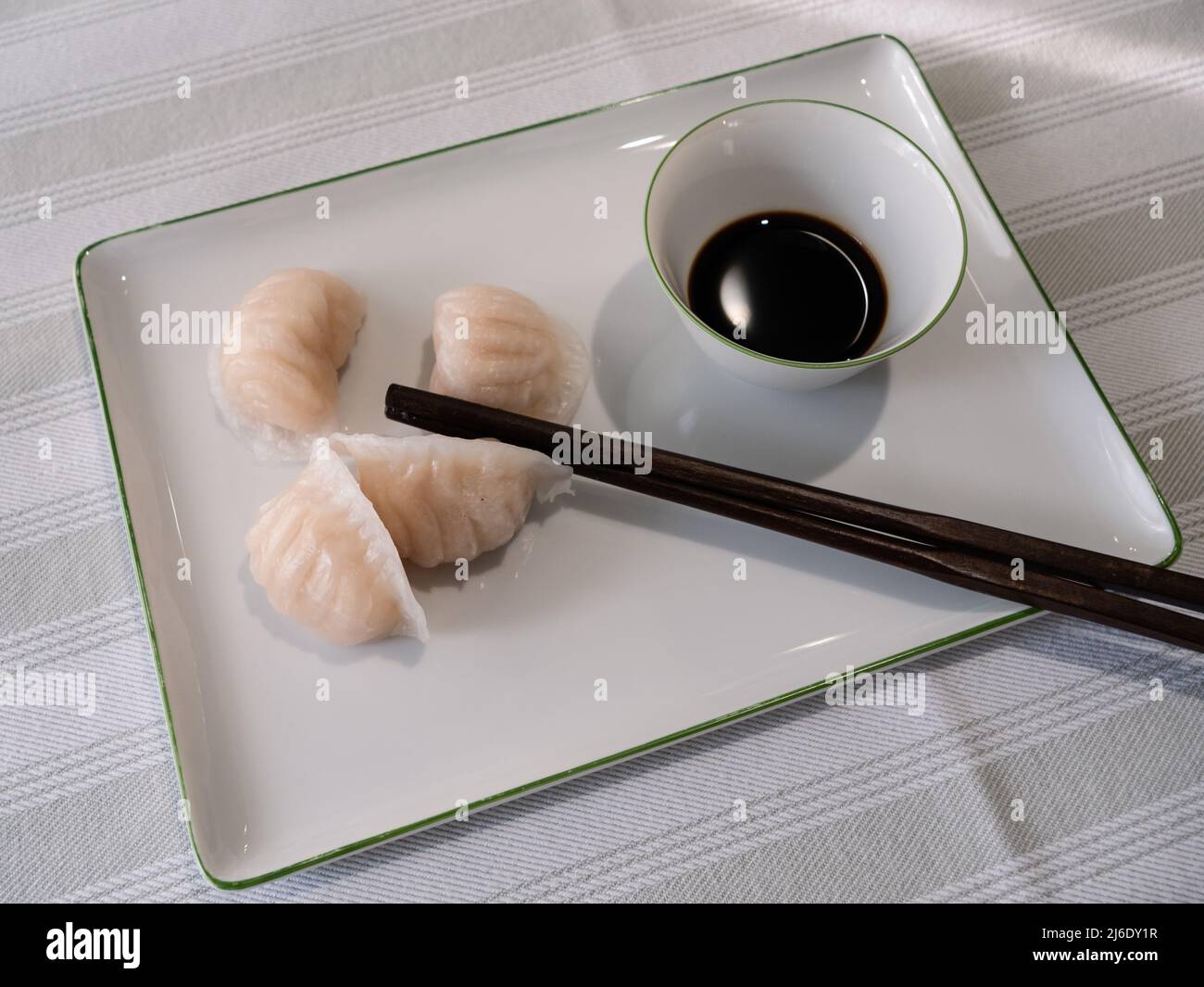 Dim Sum oder Har Gow Shrimp Dumpling mit Essstäbchen und Sojasauce, auch als ha-Gow, Heukau oder Hakao anglizisiert Stockfoto
