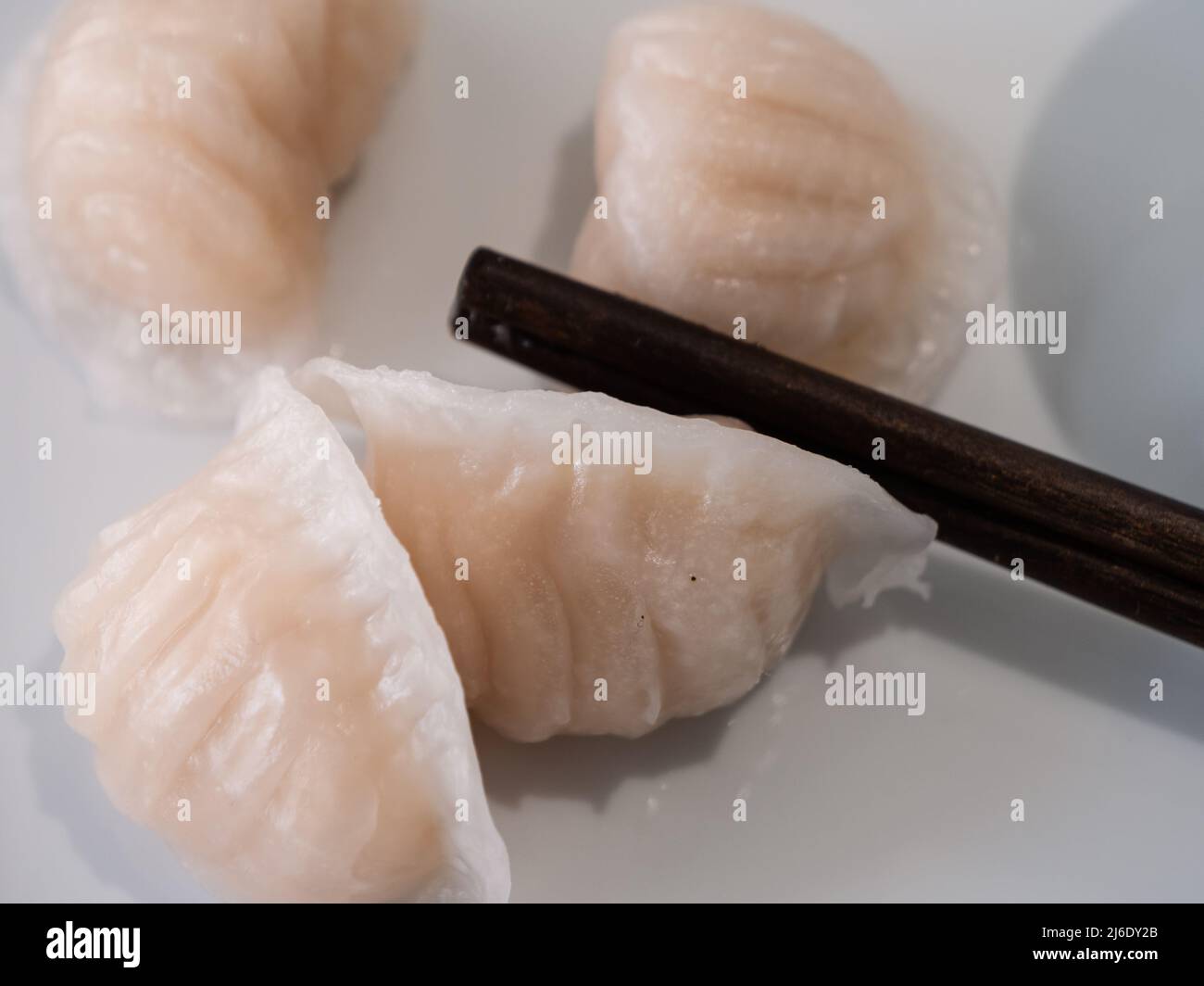 Dim Sum oder Har Gow Shrimp Dumpling mit Essstäbchen, auch als ha-Gow, Heukau oder Hakao anglizisiert Stockfoto
