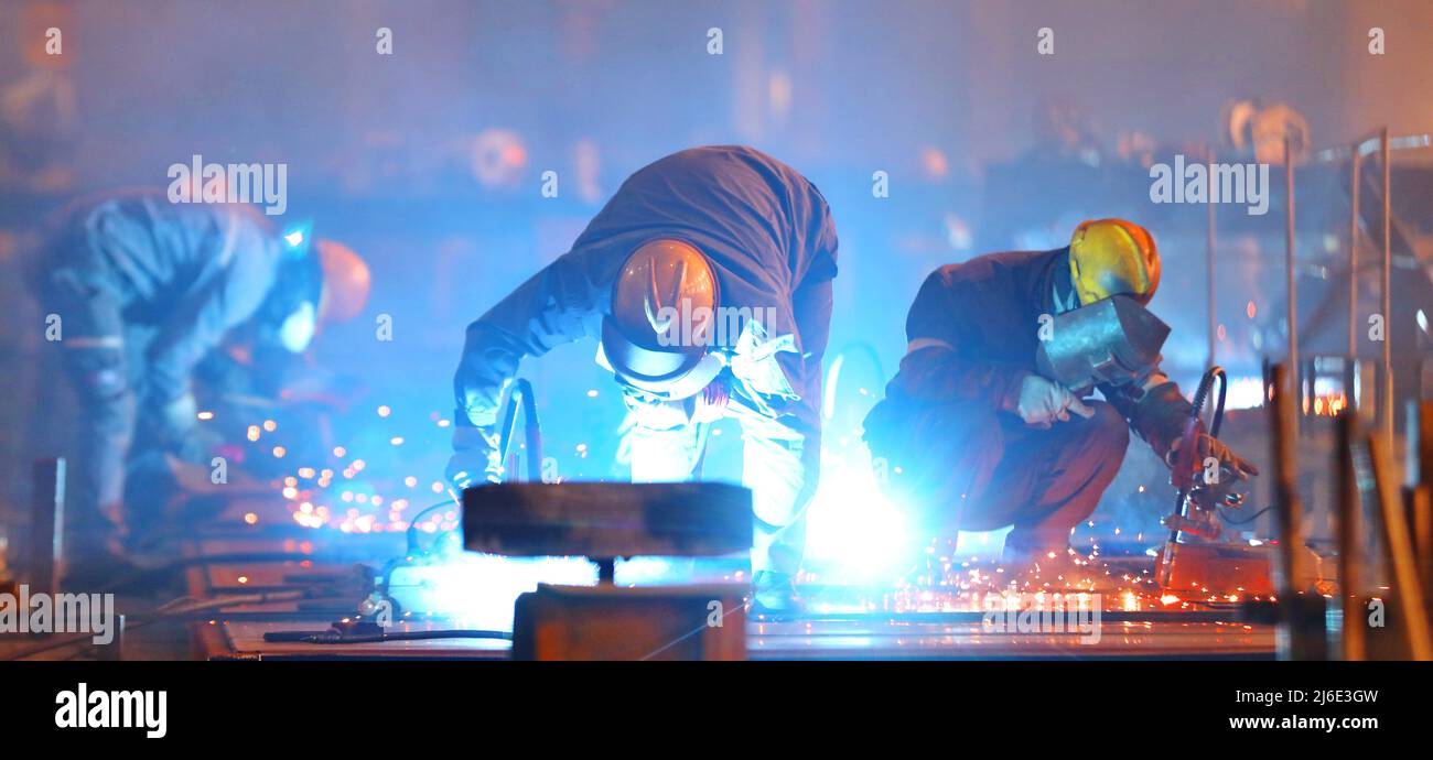 (220501) -- HARBIN, 1. Mai 2022 (Xinhua) -- Arbeiter sind beschäftigt bei der China Railway Rolling Stock Corporation (CRRC) Qiqihar Rolling Stock Co., Ltd in Qiqihar, nordöstlich der chinesischen Provinz Heilongjiang, 8. April 2022. Der Internationale Arbeitertag, auch bekannt als Maifeiertag, wird am 1. Mai in China begangen. Die Fotogruppe nutzt Licht und Schatten in der Fotografie, um die Arbeitsszene der Industriearbeiter in der chinesischen Provinz Heilongjiang zu skizzieren. (Foto von Song Yanjun/Xinhua) Stockfoto