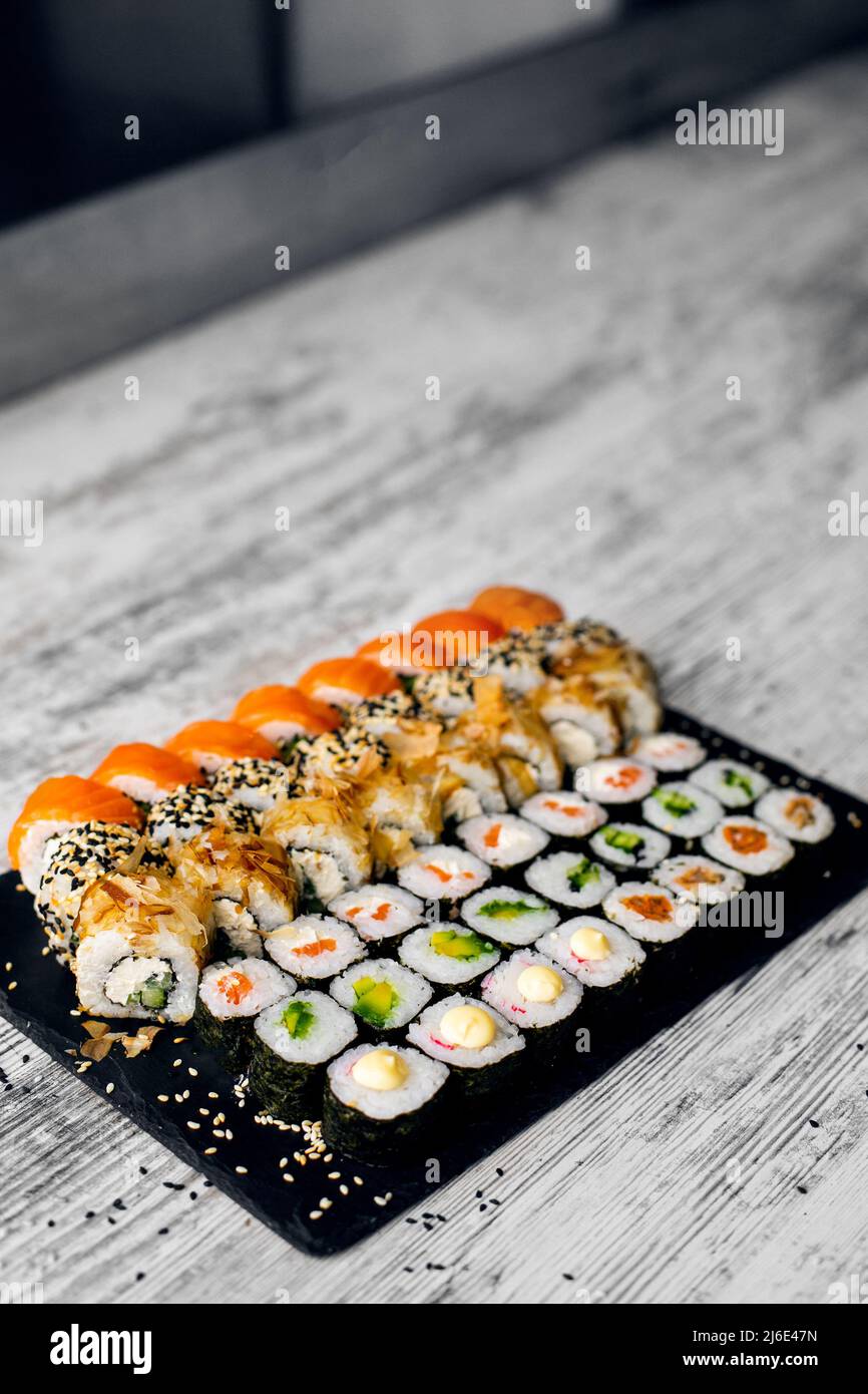 Sushi Set Nigiri und Sushi-Rollen auf schwarzem Stein Schieferteller Board. Platz für tex. instagram Geschichten Stockfoto